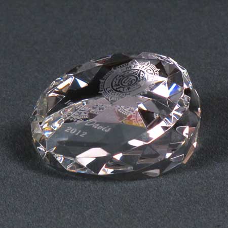 A faceted crystal round paperweight