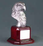 Image of a silver colored eagle bust on a piano finish red base