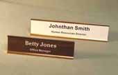 This is a image of two gold tone desk name plates with engraved plastic inserts 