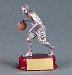 This is a pewter color male basketball player dribbling a ball while standing on a red base